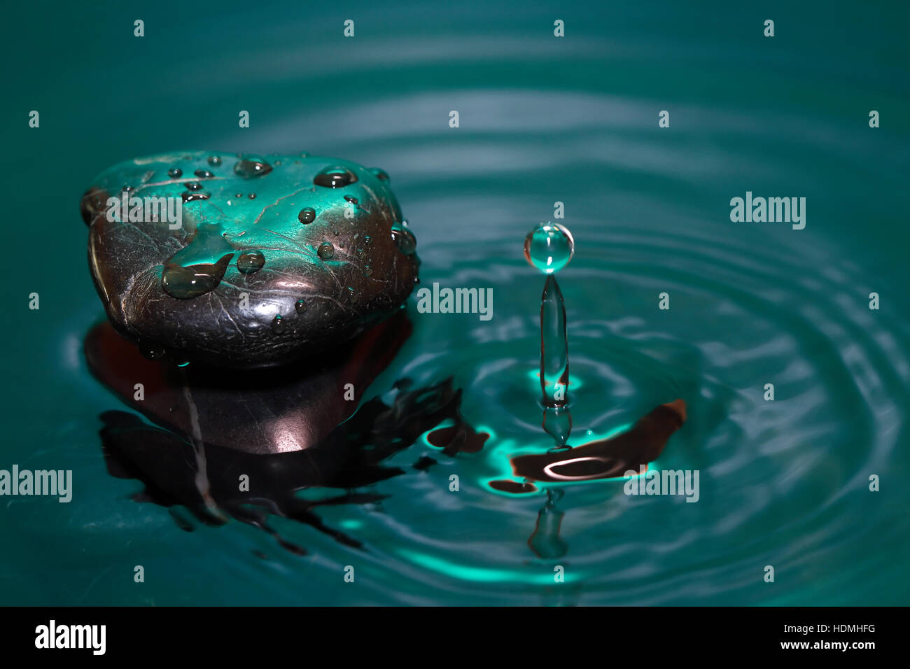 Meditation concept. Stone with drops in splashing water Stock Photo