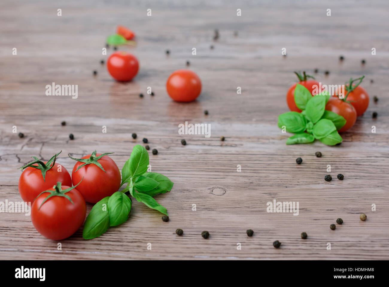 Scattered cherry tomatoes and pepper balls with basil leaves lay on the ...