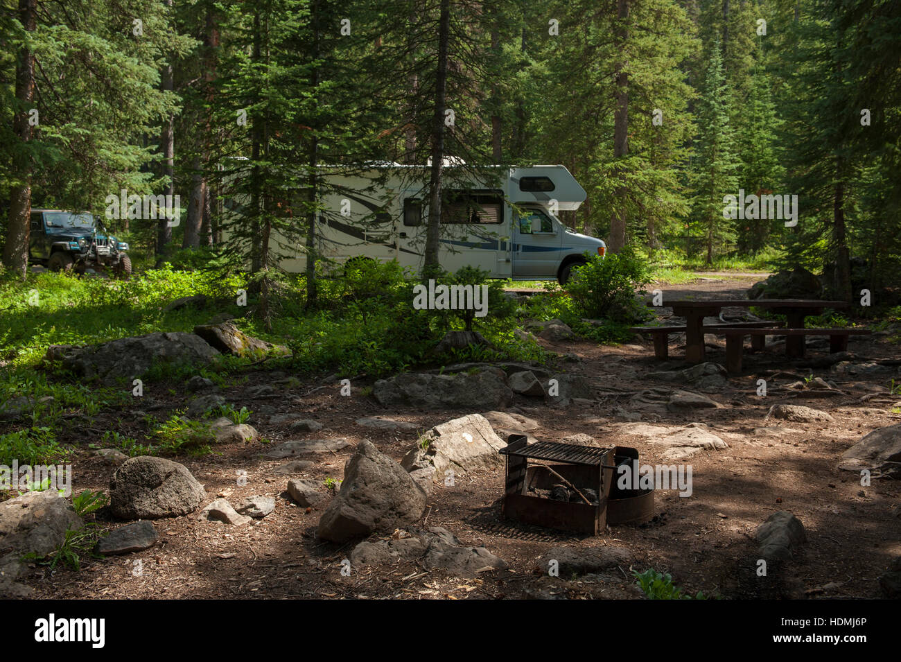 A Recreational Vehicle (RV) and Jeep at a Forest Service camp site. Stock Photo