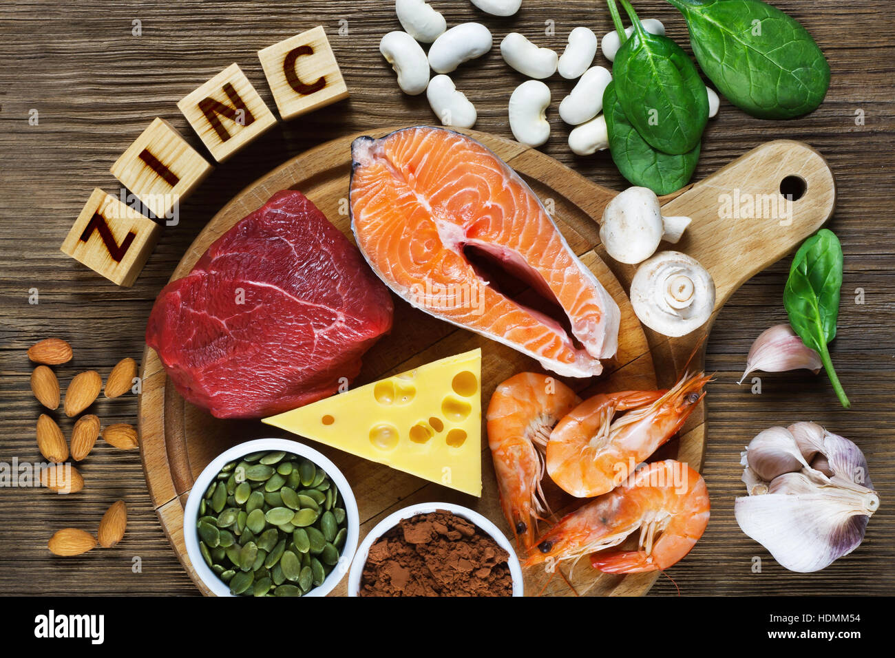 Foods High in Zinc as salmon, shrimps, beef, yellow cheese, spinach, mushrooms, cocoa, pumpkin seeds, garlic, bean and almonds. Top view Stock Photo
