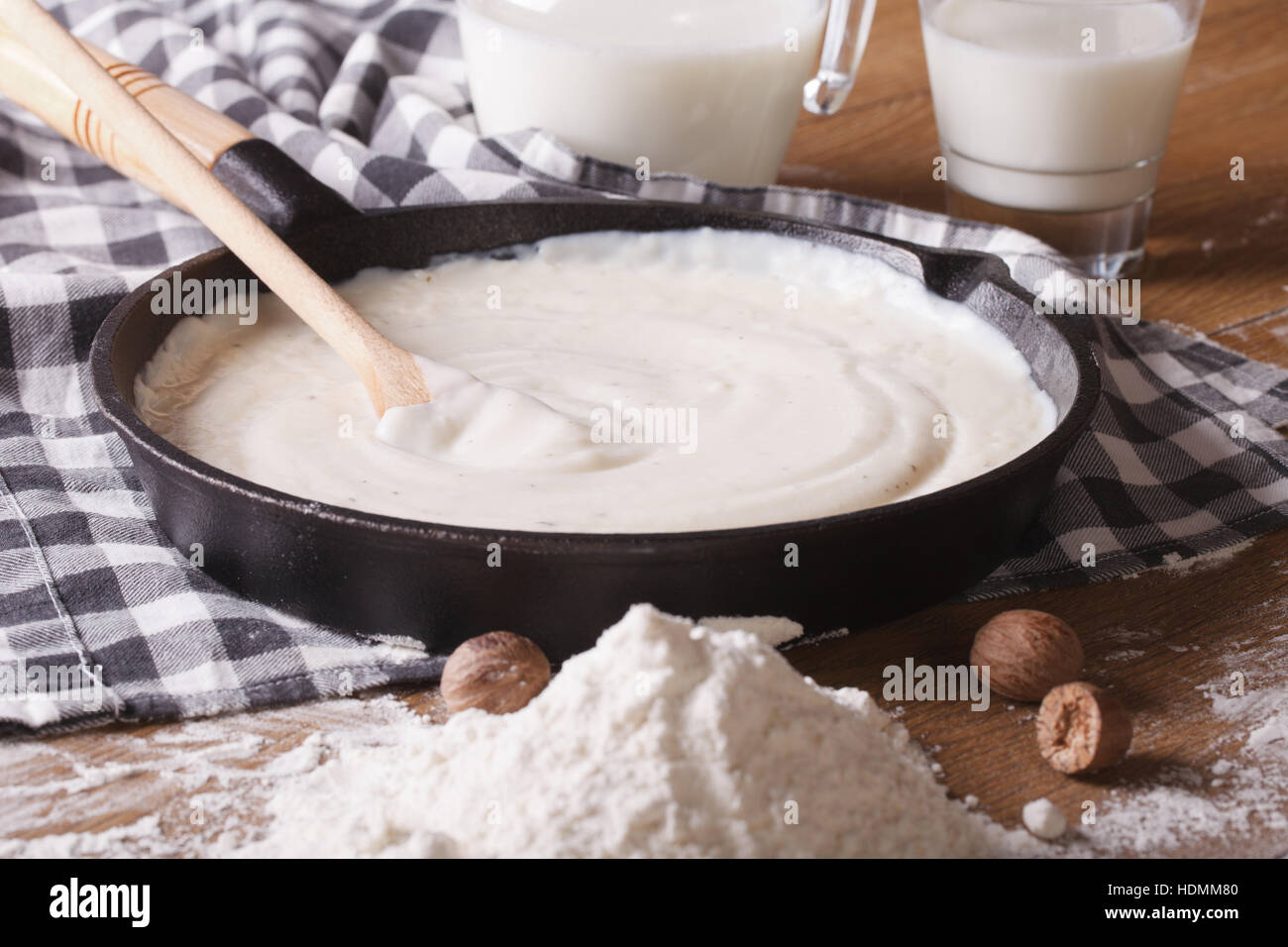preparation of bechamel sauce in a pan and flour, milk on the table