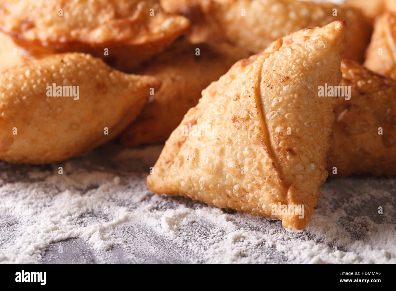 A pile of baking samosas macro on the table with flour. horizontal Stock Photo