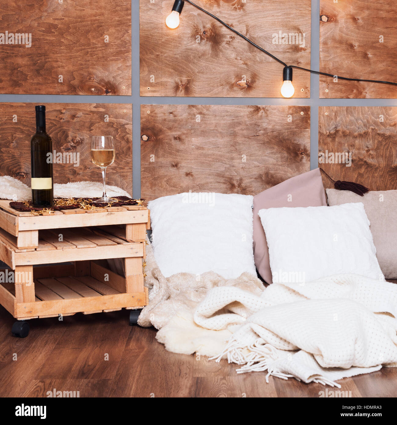 Glass of white wine and bottle in modern loft interior with light ...