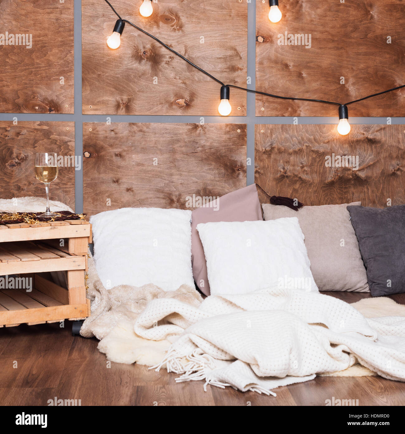 Glass of white wine in modern loft interior with light garland on ...
