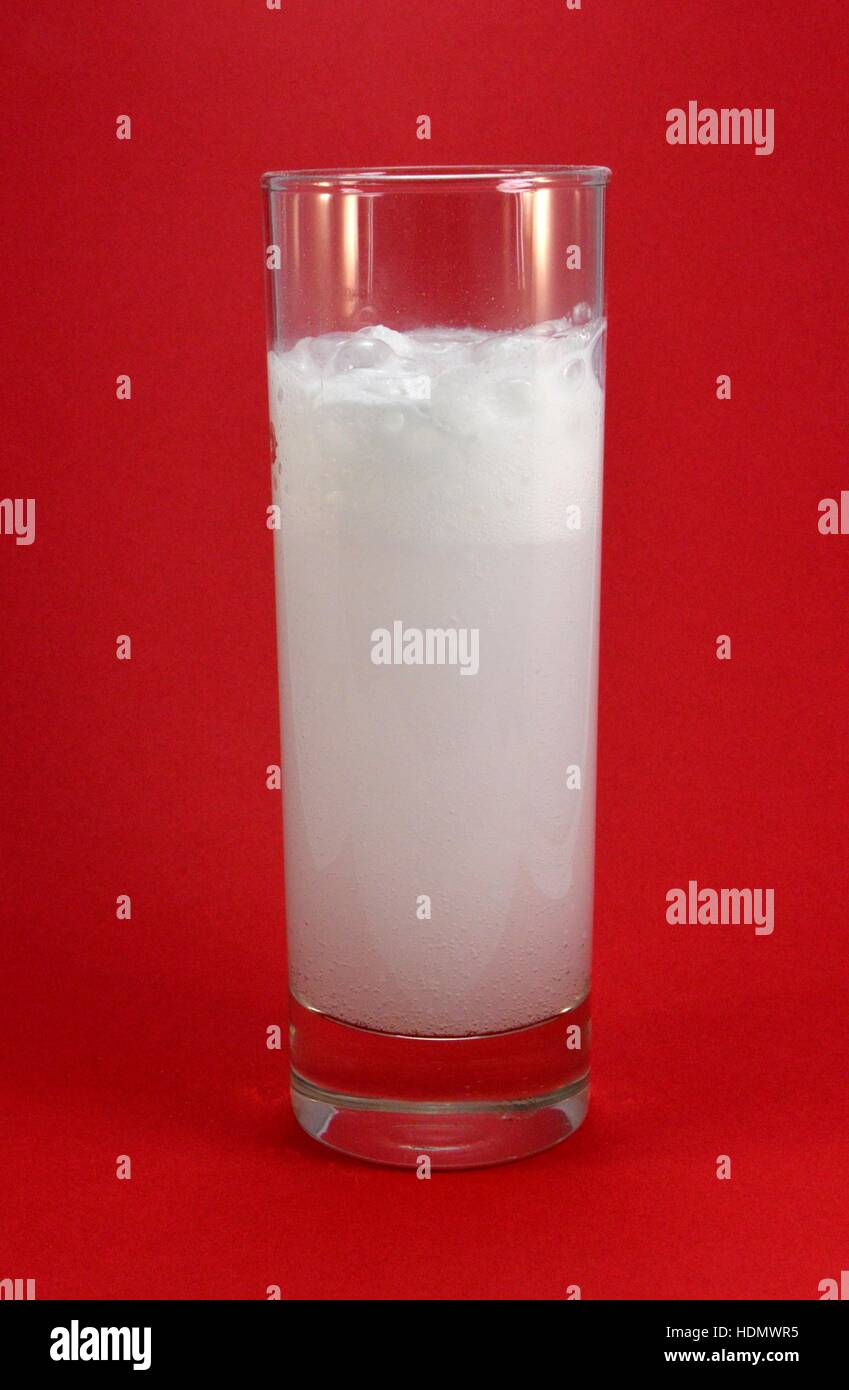 Long drink glass containing water with an effervescent agent Stock Photo