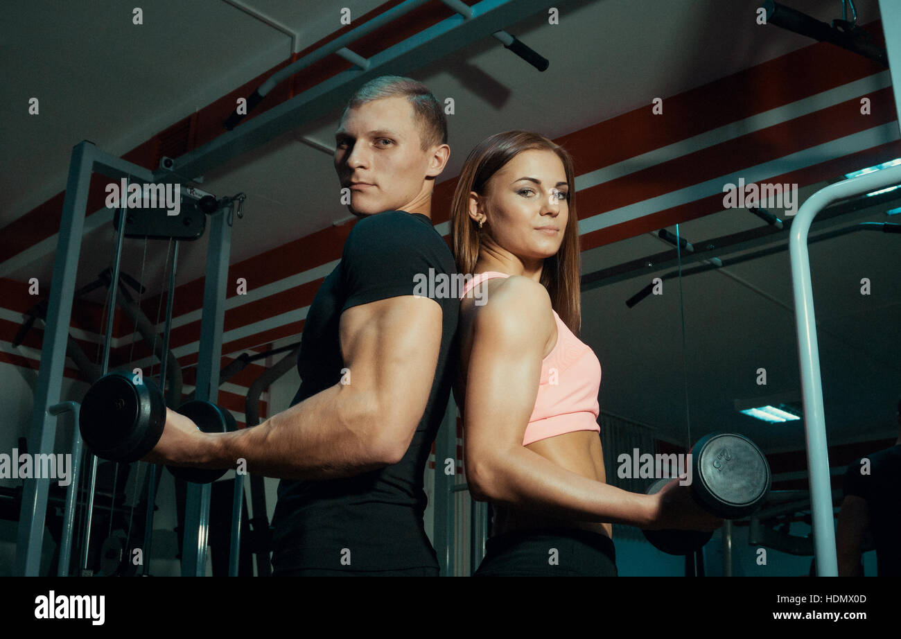 Man and woman with dumbbells in the gym Stock Photo - Alamy