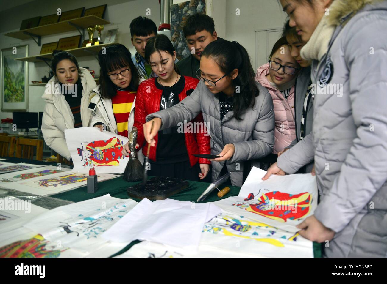 Liaocheng, Liaocheng, China. 12th Dec, 2016. Liaocheng, CHINA-December 12 2016: (EDITORIAL USE ONLY. CHINA OUT) .Students make woodblock prints at Liaocheng University in Liaocheng, east China's Shandong Province, December 12th, 2016. Woodblock printing is a technique for printing text, images or patterns used widely throughout East Asia and originating in China in antiquity as a method of printing on textiles and later paper. As a method of printing on cloth, the earliest surviving examples from China date to before 220 AD, and woodblock printing remained the most common East Asian metho Stock Photo