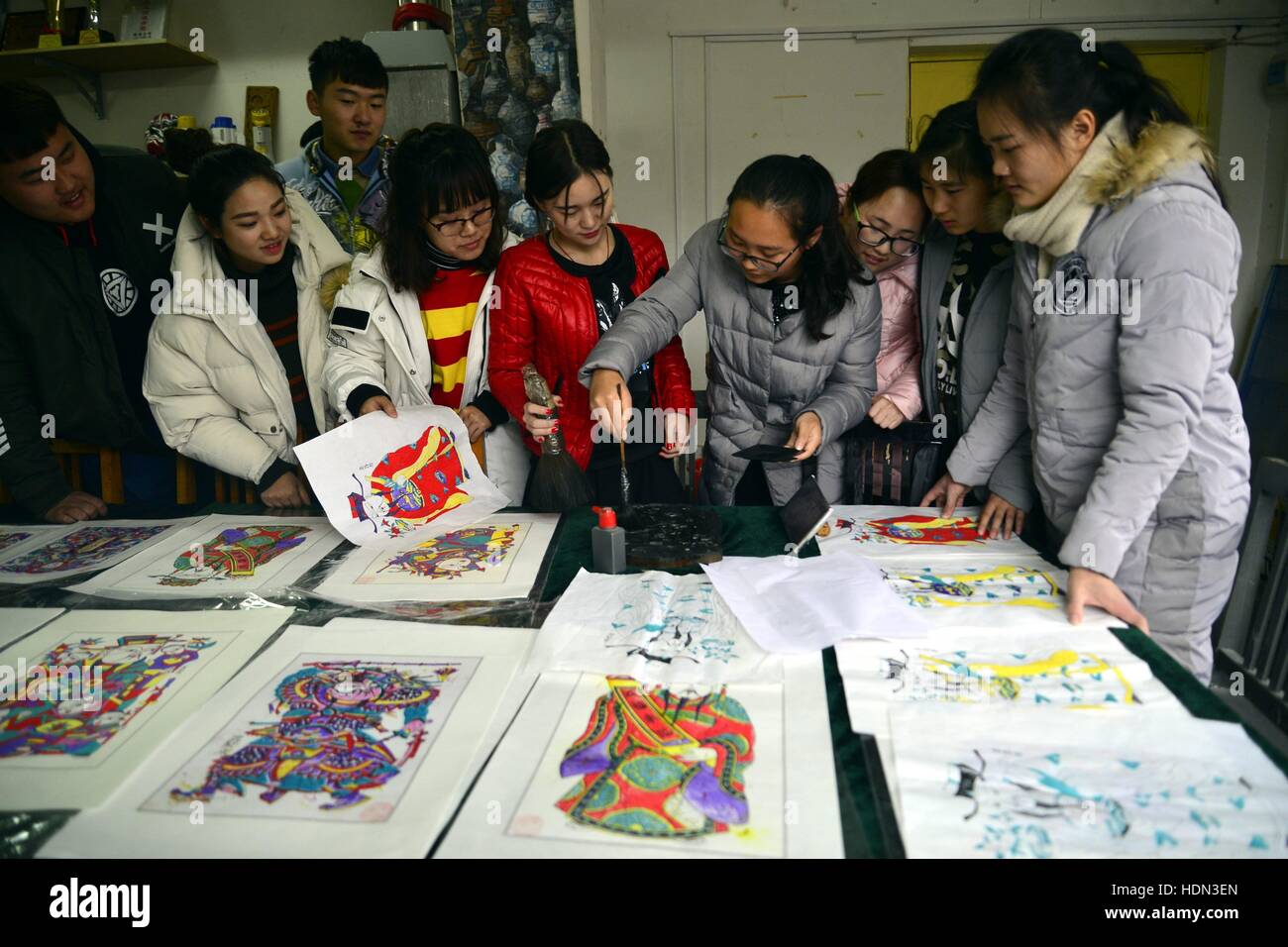 Liaocheng, Liaocheng, China. 12th Dec, 2016. Liaocheng, CHINA-December 12 2016: (EDITORIAL USE ONLY. CHINA OUT) .Students make woodblock prints at Liaocheng University in Liaocheng, east China's Shandong Province, December 12th, 2016. Woodblock printing is a technique for printing text, images or patterns used widely throughout East Asia and originating in China in antiquity as a method of printing on textiles and later paper. As a method of printing on cloth, the earliest surviving examples from China date to before 220 AD, and woodblock printing remained the most common East Asian metho Stock Photo