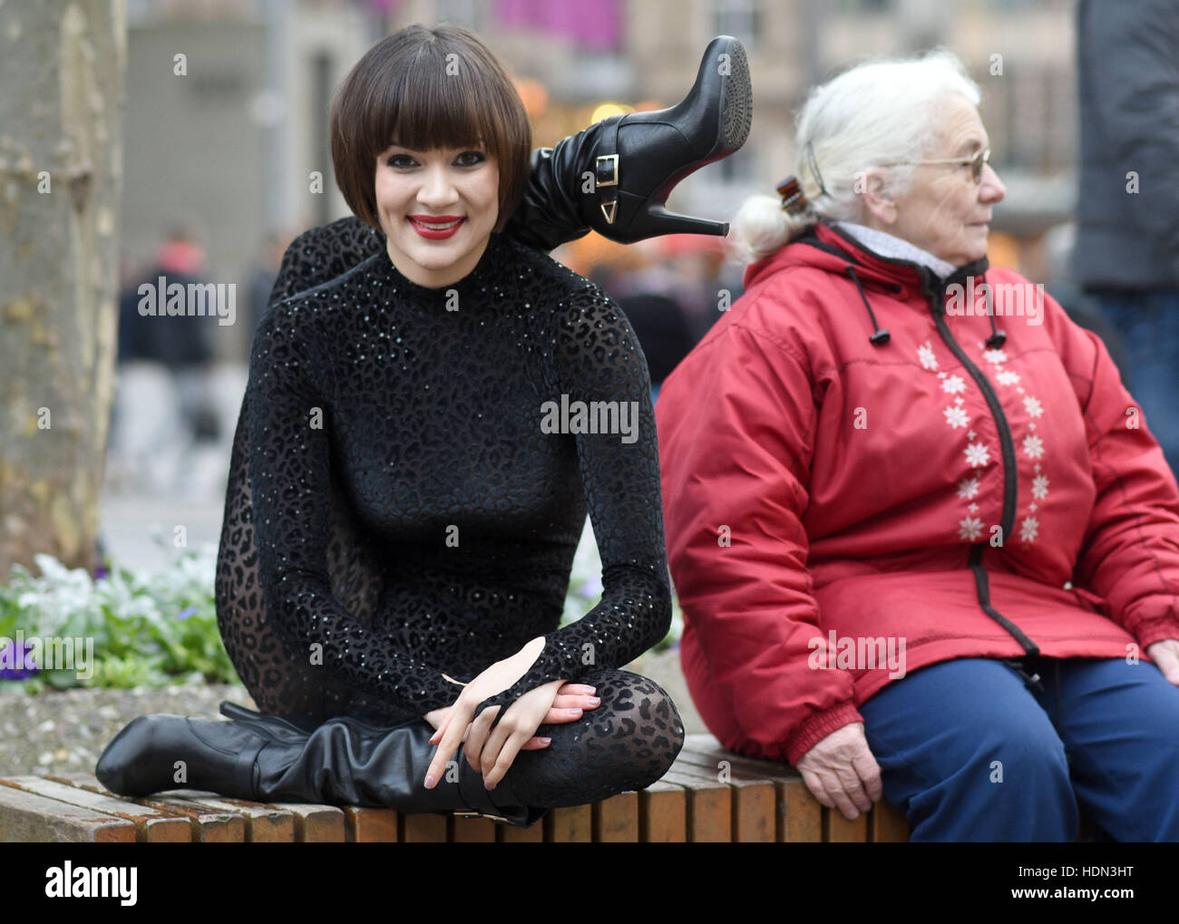 Cologne, Germany. 12th Dec, 2016. Contortionist Alina Ruppel shows off her  skills beside a member of the public on a bench in Cologne, Germany, 12  December 2016. Ruppel is due to compete