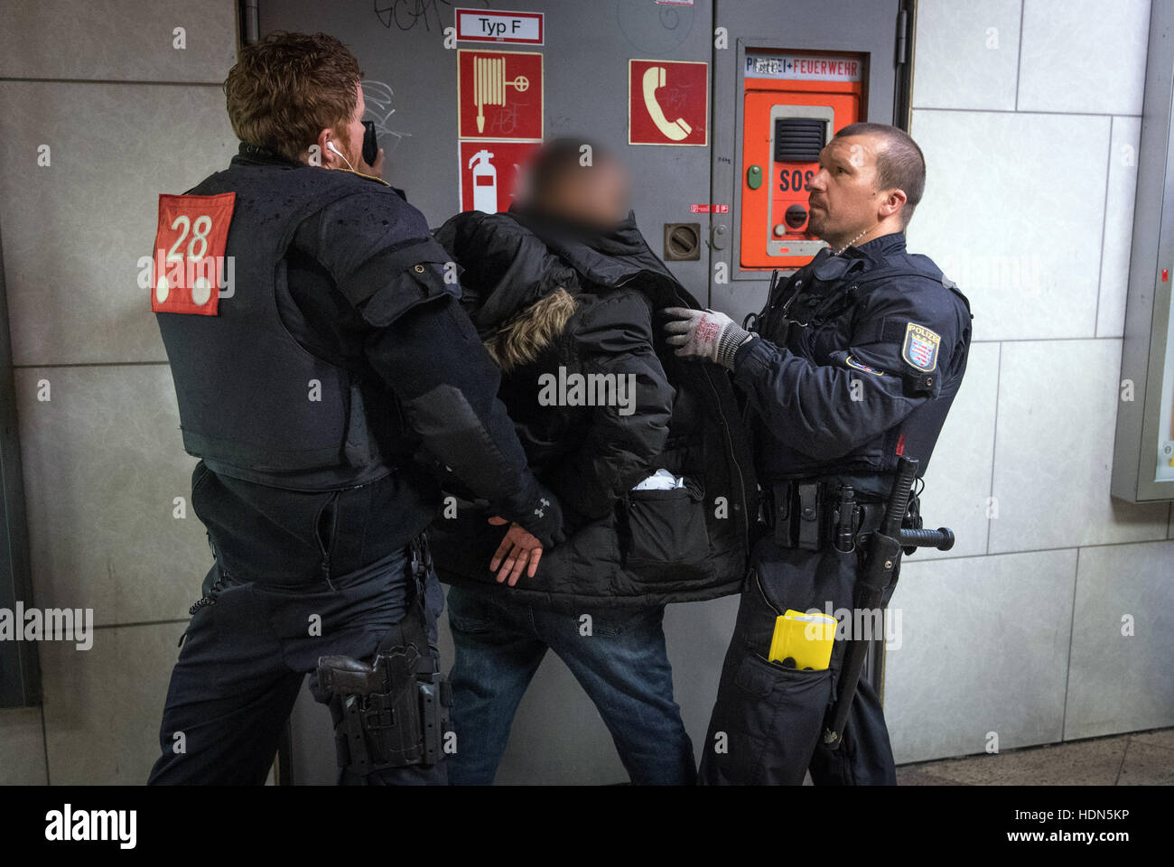 Frankfurt, Germany. 13th Dec, 2016. Police officers with a suspect in Frankfurt Central Station, Frankfurt am Main, Germany, 13 December 2016. The police has stepped up its patrols in the station in order to prevent crime and the drug trade. - ATTENTION EDITORS: The face of the suspect has been pixelated in order to preserve his/her anonymity - Photo: Boris Roessler/dpa © dpa picture alliance/Alamy Live News Stock Photo