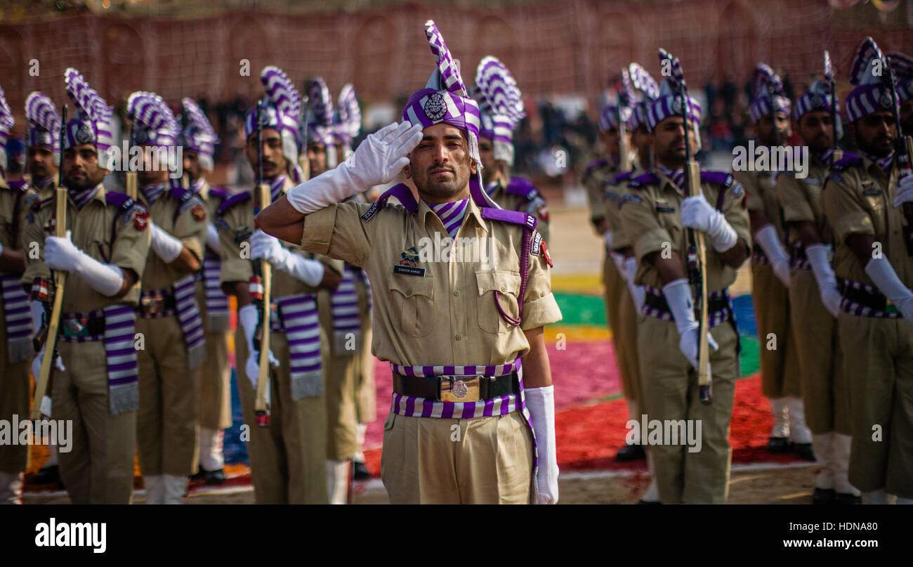 Lethpora, Jammu and Kashmir, India. 14th Dec, 2016. Jammu and Kashmir Police (JKP) men salute during their passing-out parade on December 14, 2016 in Lethpora 25 km (15 miles) south of Srinagar, the summer capital of, Indian Administered Kashmir, India.After completing their training, nearly 355 constables of JK police took oath during their passing out parade in south Kashmir's Pulwama District. The year-long rigourous training involves physical training, weapons handling, and lessons in counter-insurgency operations among other things. Credit:  ZUMA Press, Inc./Alamy Live News Stock Photo
