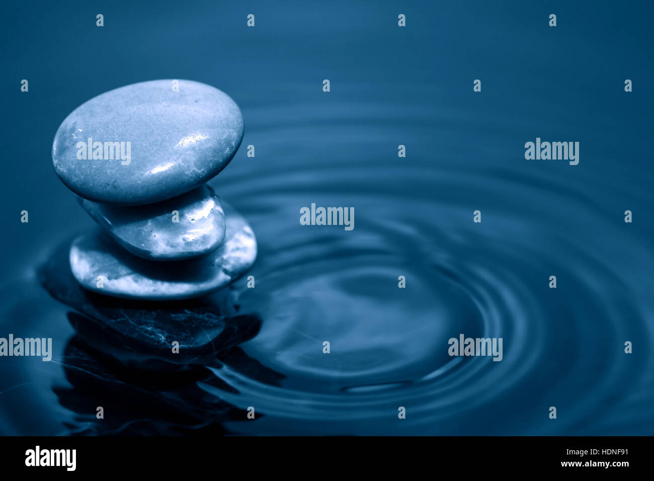 Meditation concept. Stack of stones on dark calm water Stock Photo