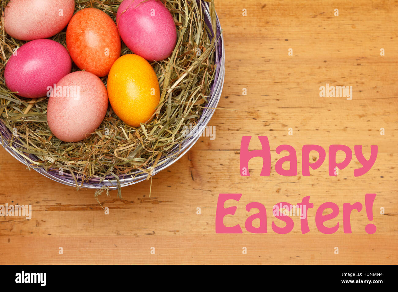 Template Happy Easter with 6 Easter Eggs in soft colors in a basket with straw on a vintage wooden background, retro design Stock Photo