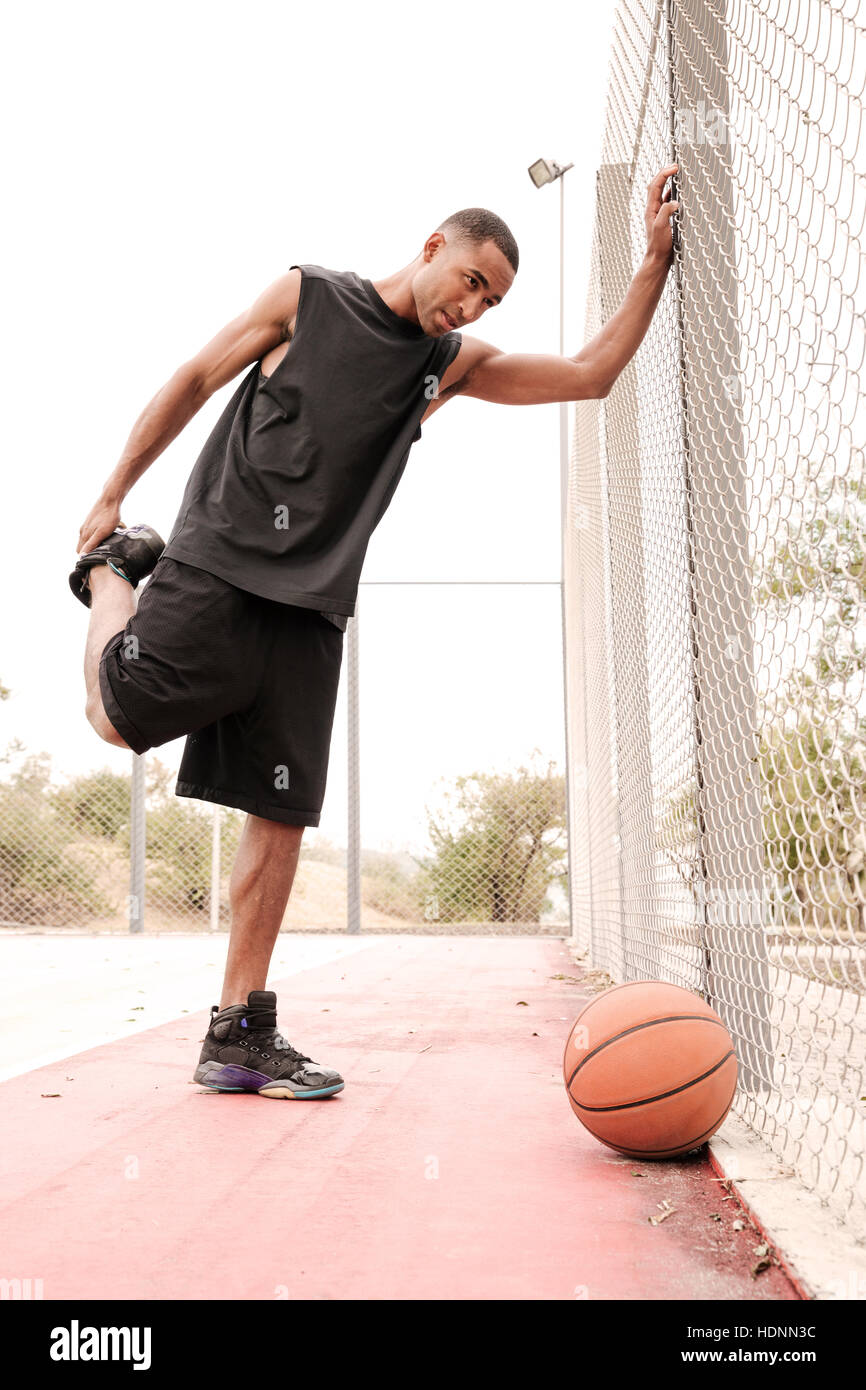 Image of young basketball player making sport exercises. Shooting at basket outdoor Stock Photo