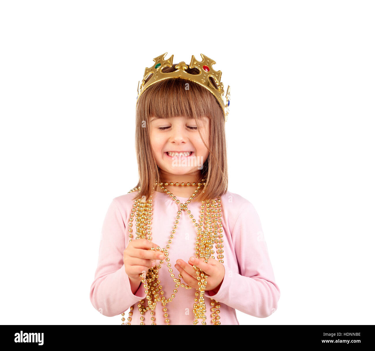 Excited small girl with golden crown and necklace isolated on a white ...