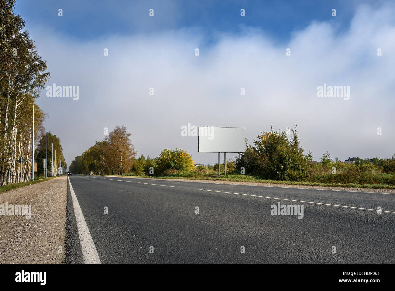 Blank billboard with highway on the background of sky with clouds Stock Photo