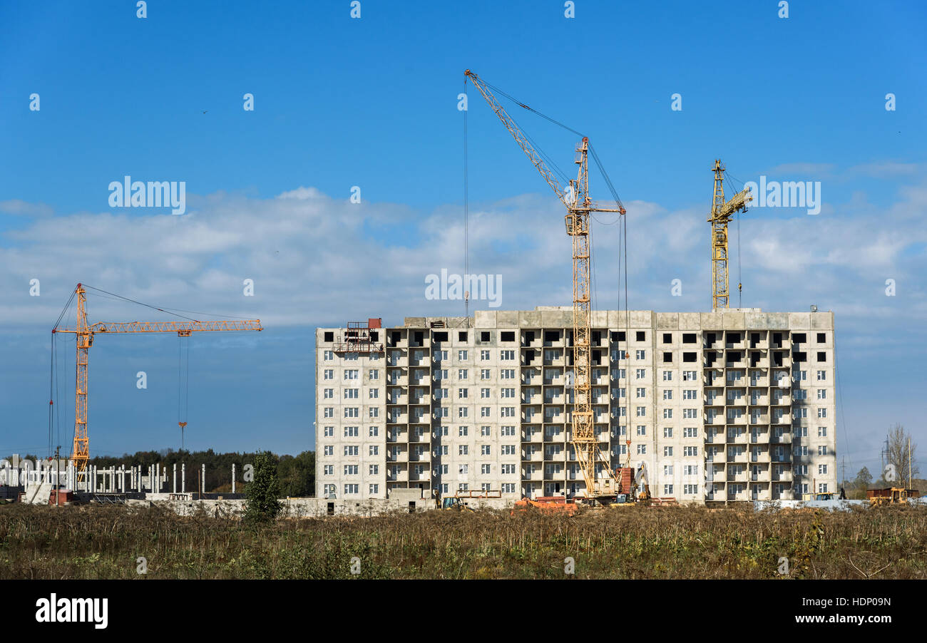 Building crane and building under construction against cloudy sky Stock Photo
