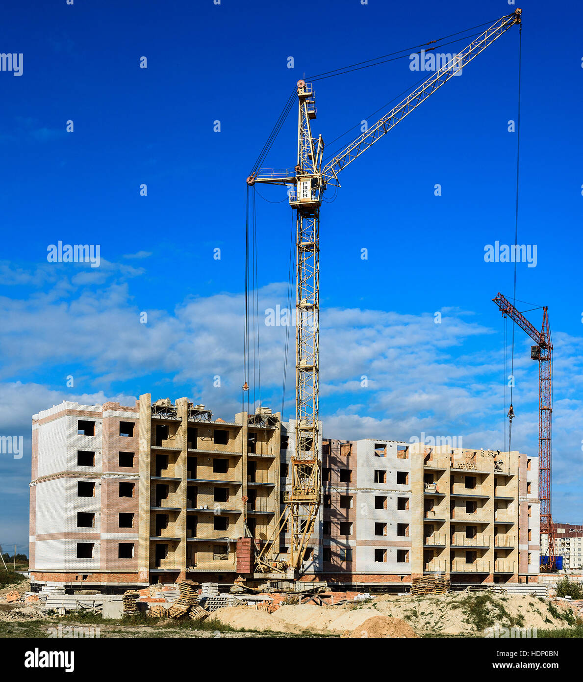 construction of apartment buildings and a crane on blue sky background Stock Photo