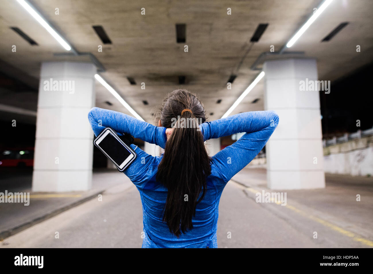 Young runner under the bridge in the evening, resting Stock Photo