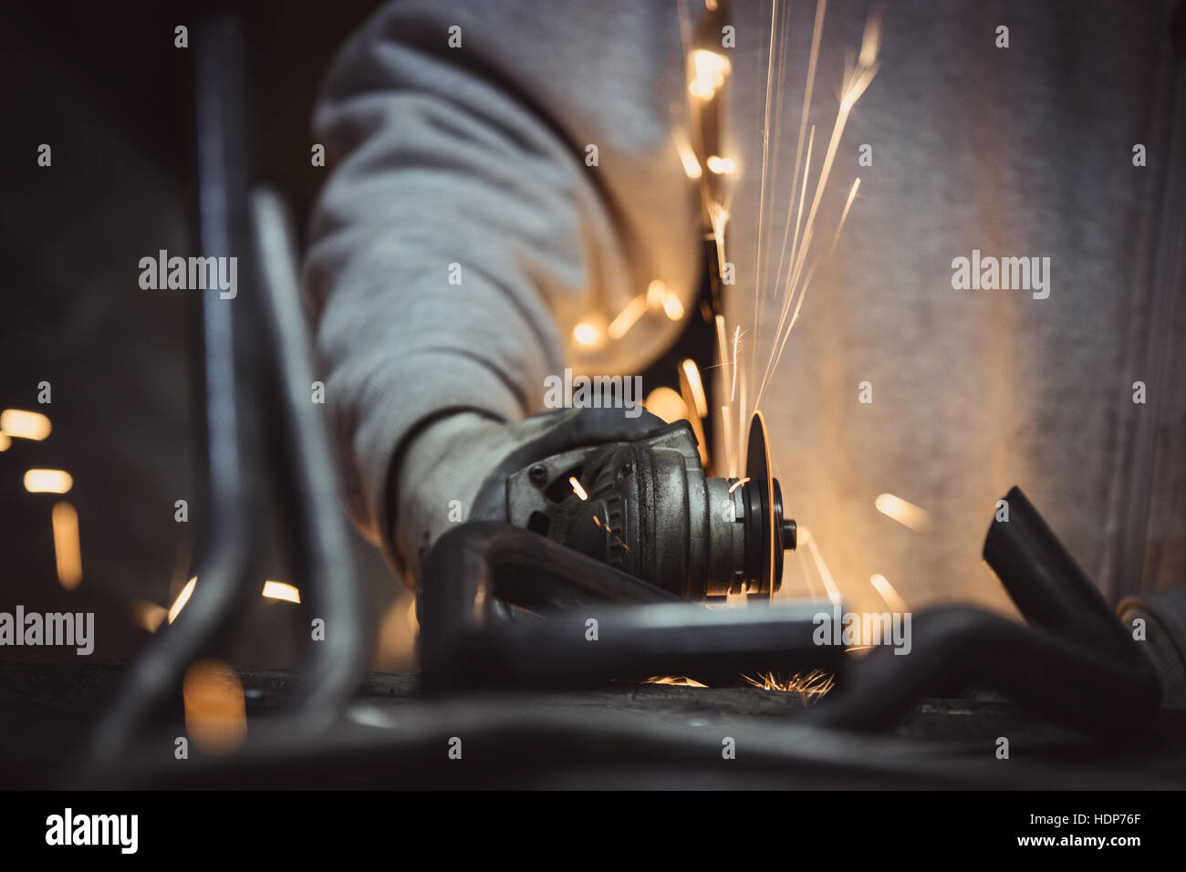 Grinding metal. Steel pipe cutting with flash of sparks close up Stock