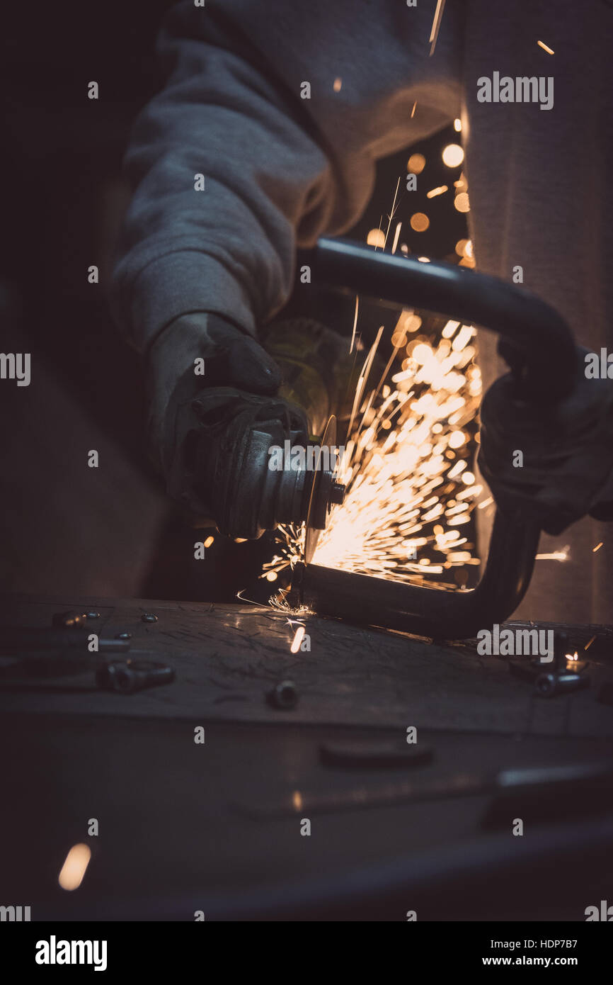 Grinding metal. Steel pipe cutting with flash of sparks close up Stock