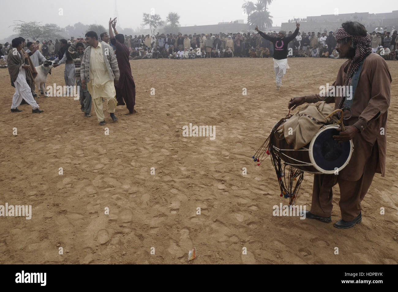 Villagers watch sheep fighting each other to annual sheep fighting festival in. The people and farmers round up their finest fighting sheep and gathered among friends to cheer on the creatures as they violently rammed into each other until their horns fell off. The “Small-Tail Han Sheep” known for their head-butting abilities, battled it out in front of hundreds of onlookers who were able to distinguish the animals by their drawn-on marks. The sheep were then divided according to age and weight in the single-elimination match. (Photo by Zubair Abbasi/Pacific Press) Stock Photo