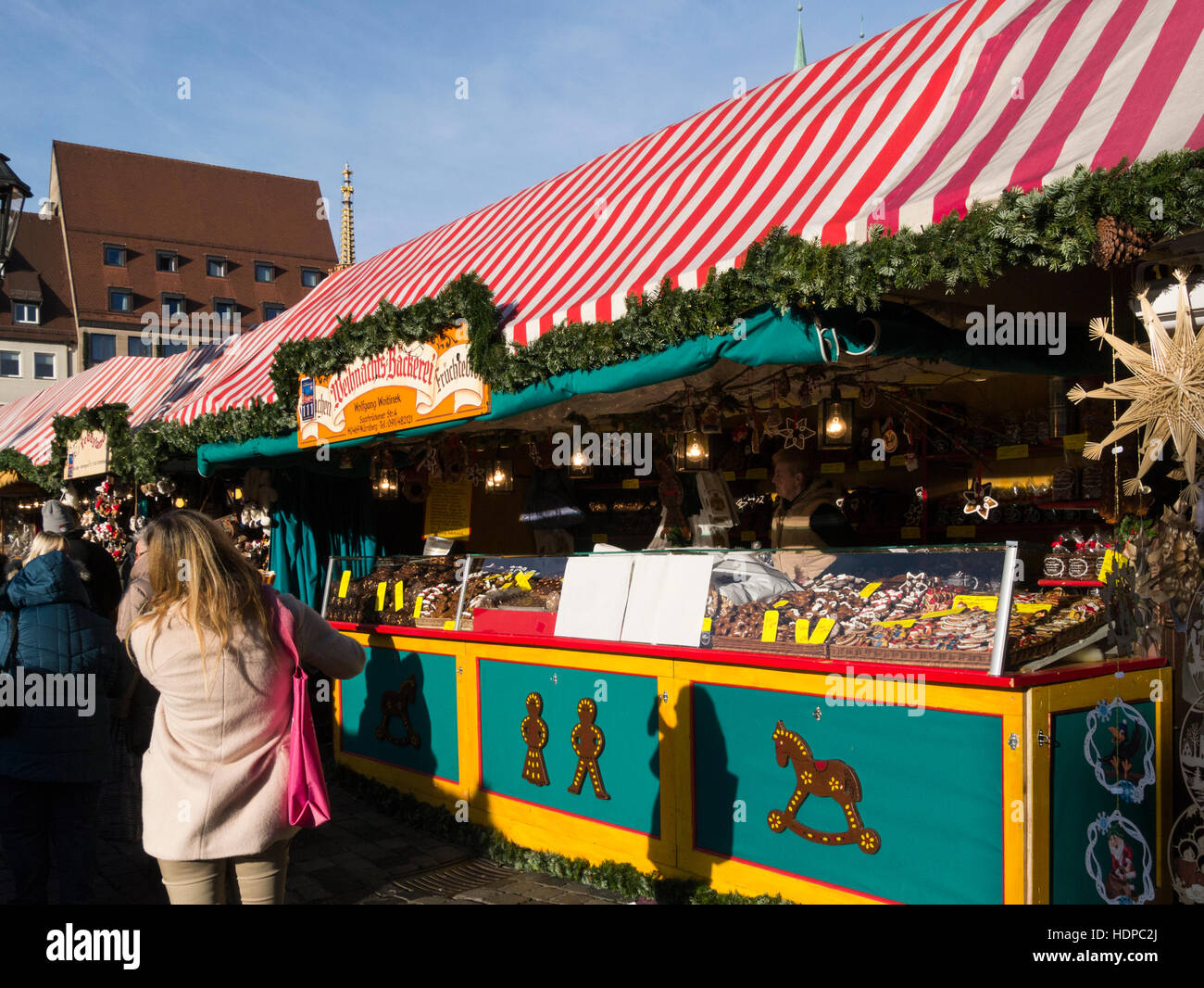 Visitors at busy Nuremberg Nurnberg Christmas Market stall checking  bakery items cakes biscuits local produce for sale Bavaria Germany EU Stock Photo