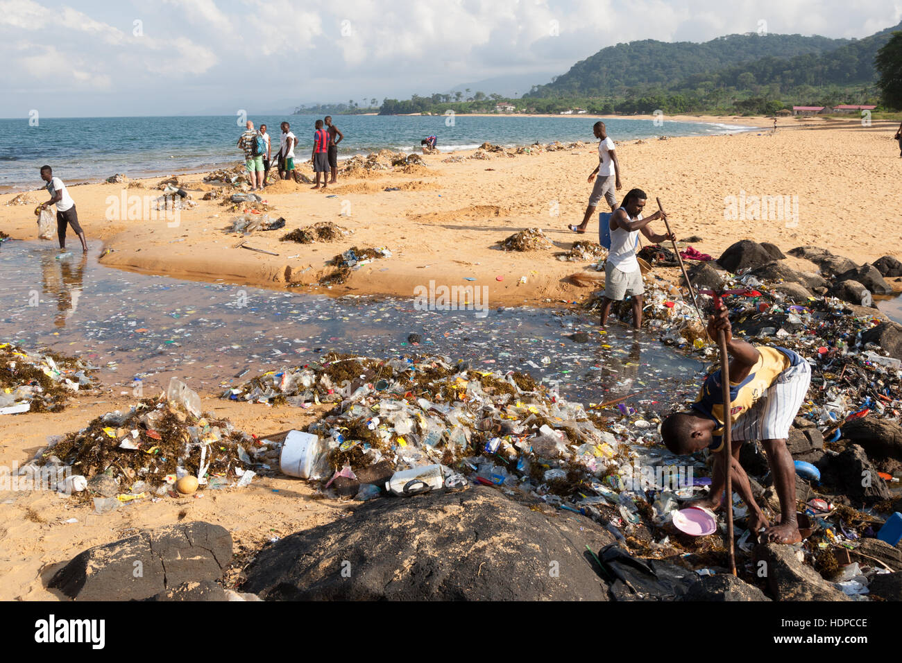 Young men are cleaning the beach from alluvial plastic Stock Photo