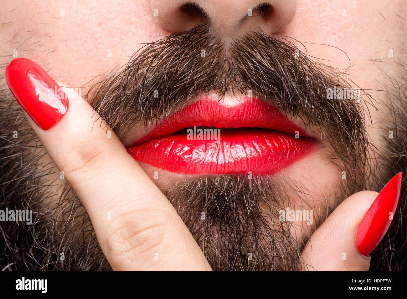 Bearded Man with Red Lipstick on His Lips and Nail Polish Stock Photo