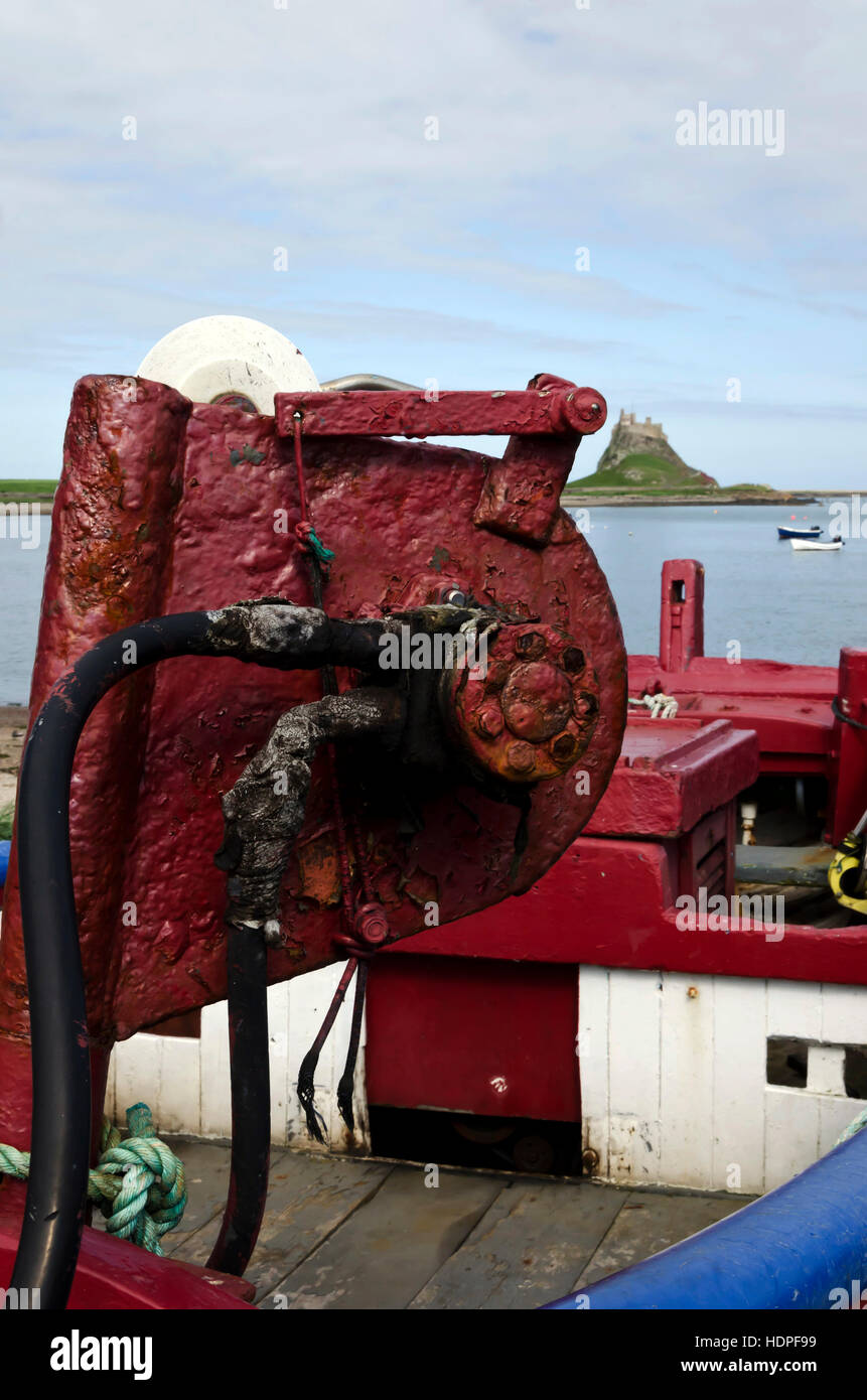 Rusty hydraulic winch on a boat near Lindisfarne (Holy Island) harbour in Northumberland, England. Stock Photo