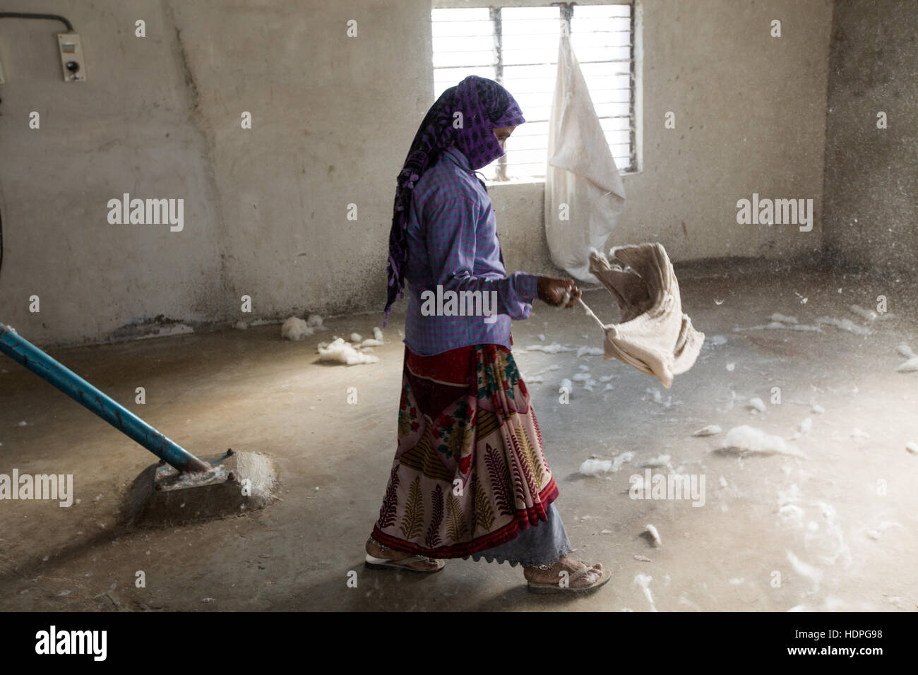 A worker sweeps a corner of a cotton ginning factory in Gujurat, north