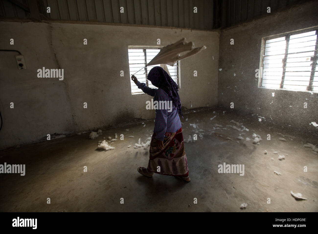 A worker sweeps a corner of a cotton ginning factory in Gujurat, north