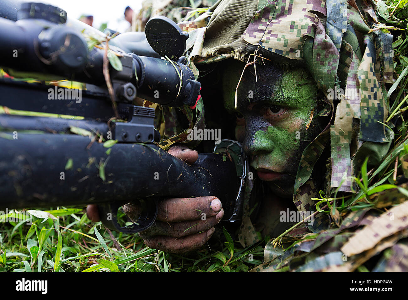 An Infanteria de Marina de Colombia scout sniper soldier sights in at a demonstration during the Marine Leaders of the Americas Conference at the Marine Infantry Training Base August 27, 2015 in Covenas, Colombia. Stock Photo