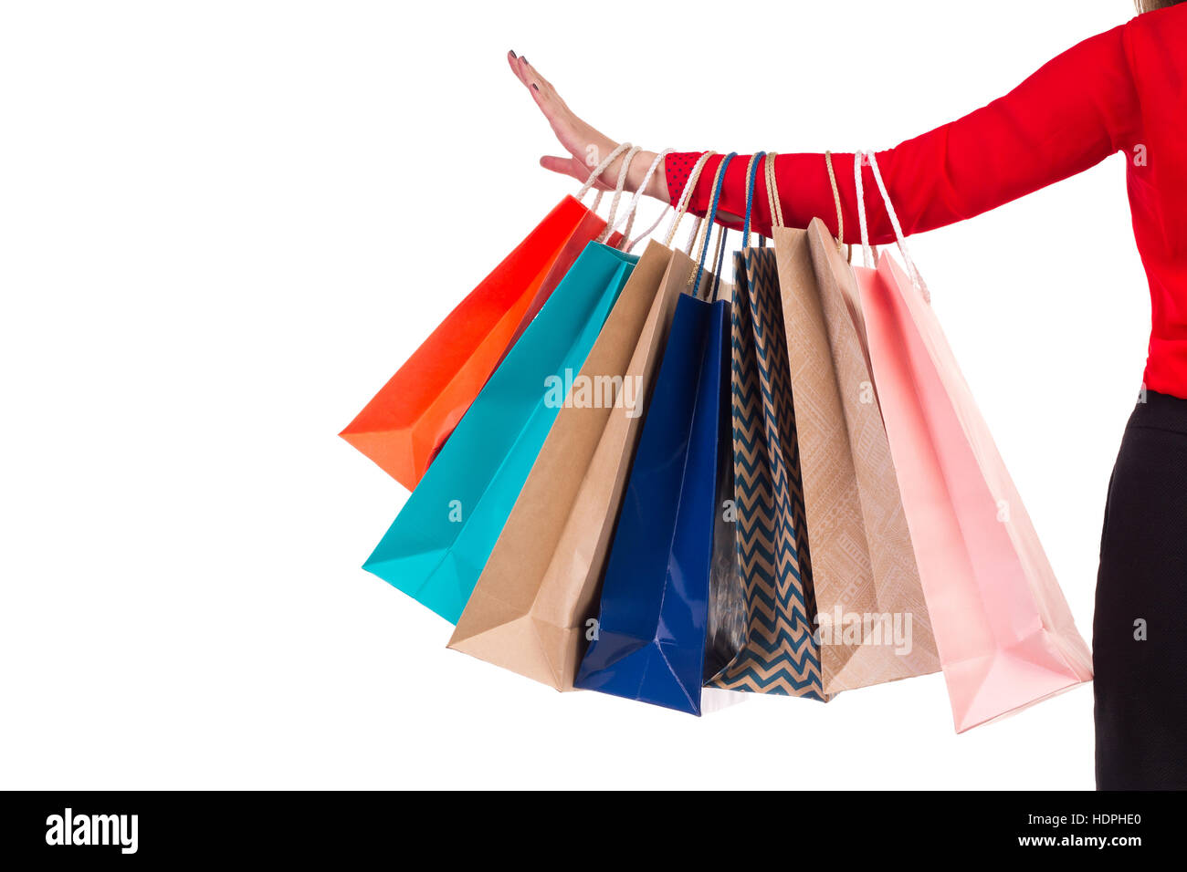 Colourful and bright shopping paper packages hanging on female red-sleeved arm Stock Photo
