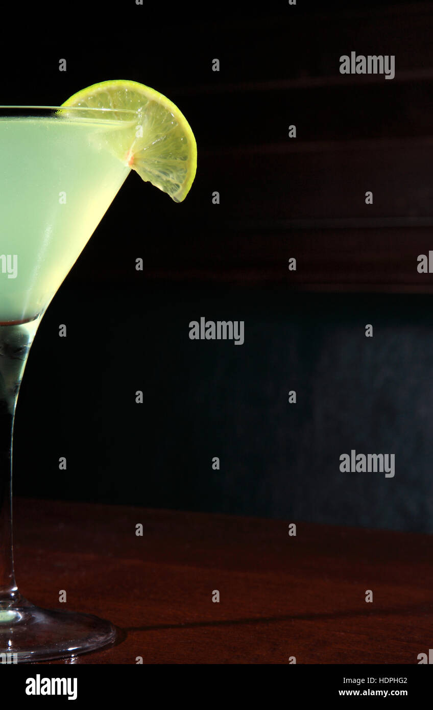 appletini cocktail with lime wheel, vodka, pineapple juice, liqueur in