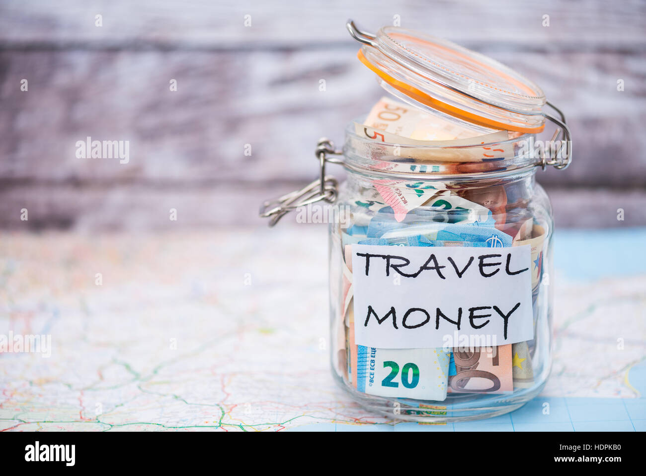 Travel money savings in a glass jar - shallow depth of field Stock Photo