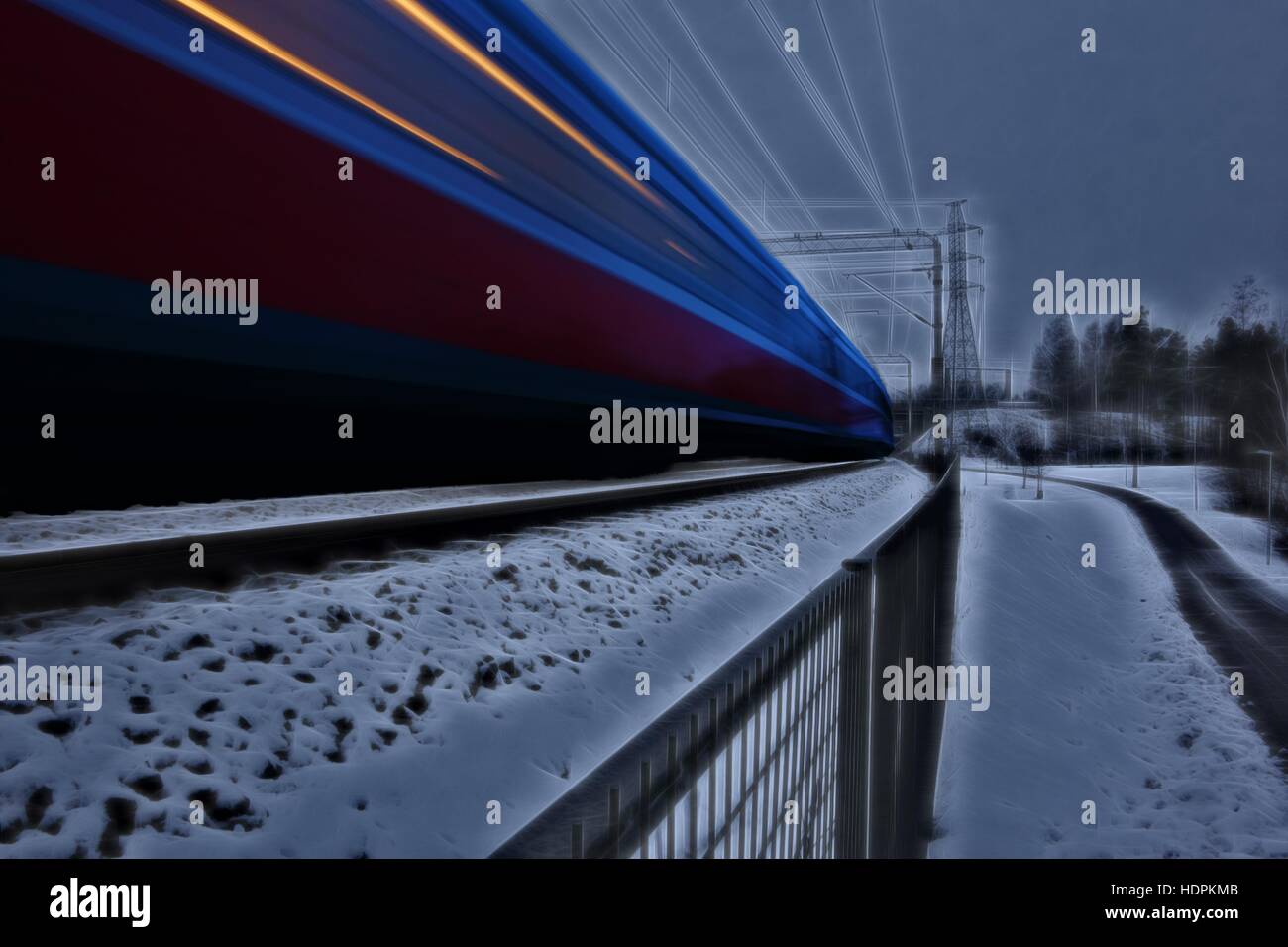 Fast moving train in winter evening setting in Helsinki, Finland with artistic post-processing of long exposure capture Stock Photo