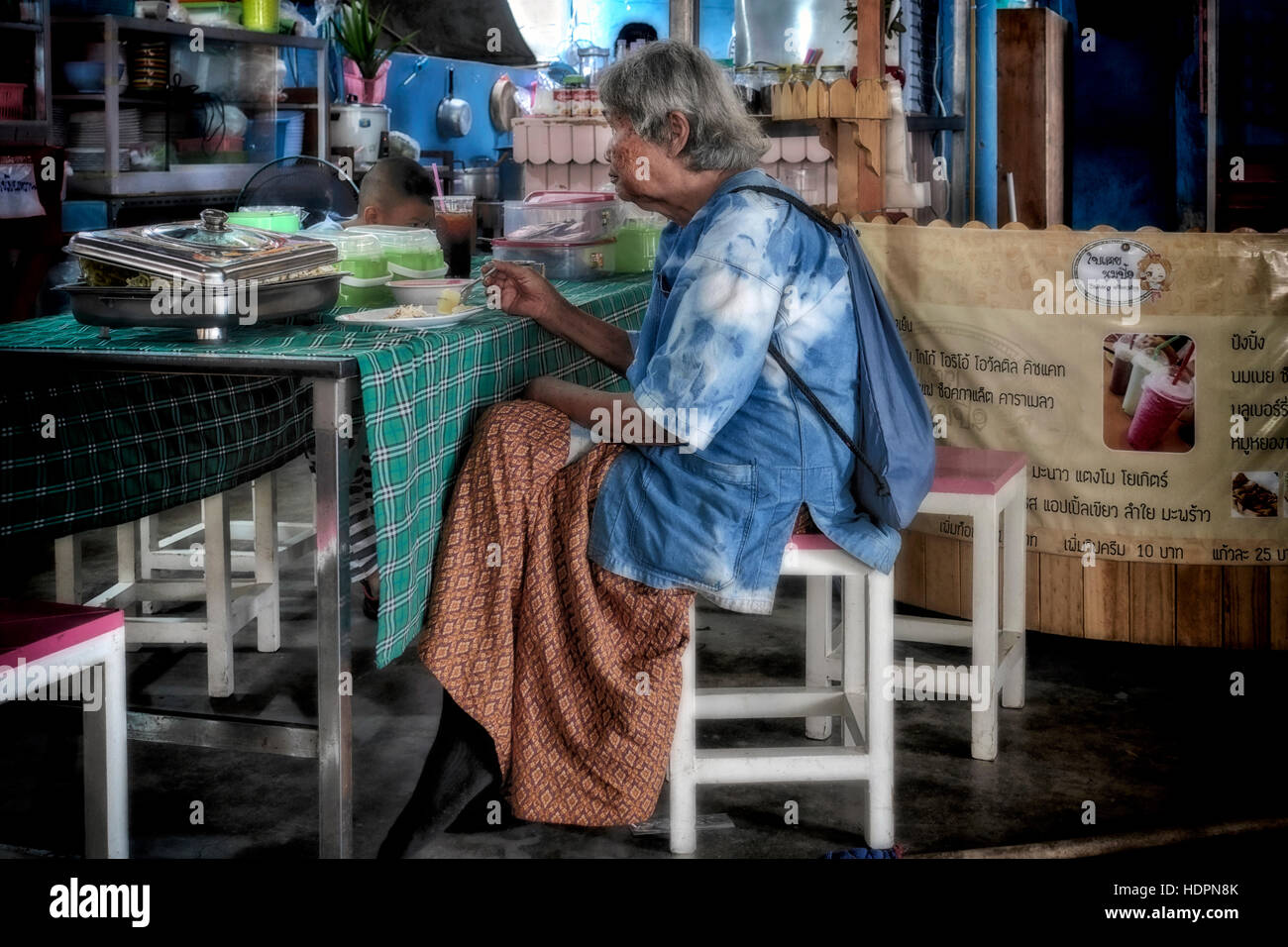 Woman alone restaurant. Thai woman eating alone in a dingy backstreet restaurant. Thailand S. E. Asia Stock Photo