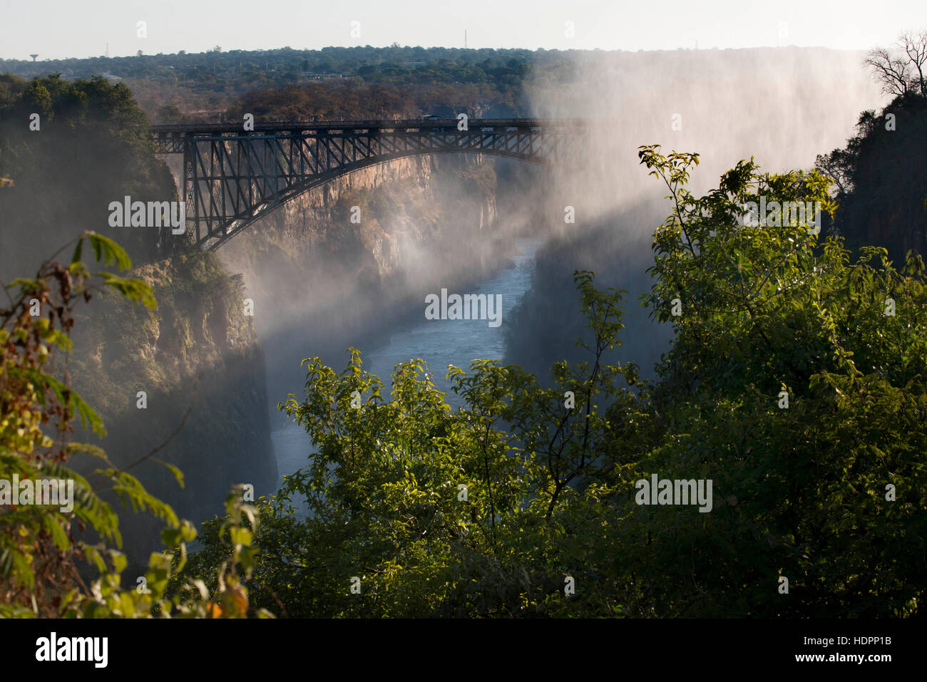 Views of Victoria Falls. Behind, the bridge between Zambia and Zimbabwe.  For more than 50 years the bridge was crossed regularly by passenger trains Stock Photo