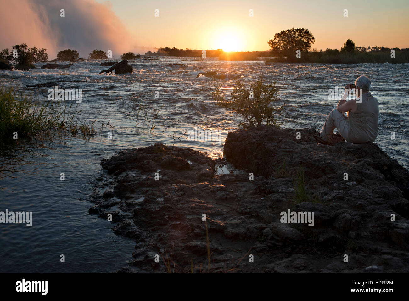 Sunset in the Victoria Falls. The Largest Waterfall in the World. The Victoria Falls have been billed as the Greatest Falling Curtain of Water on this Stock Photo