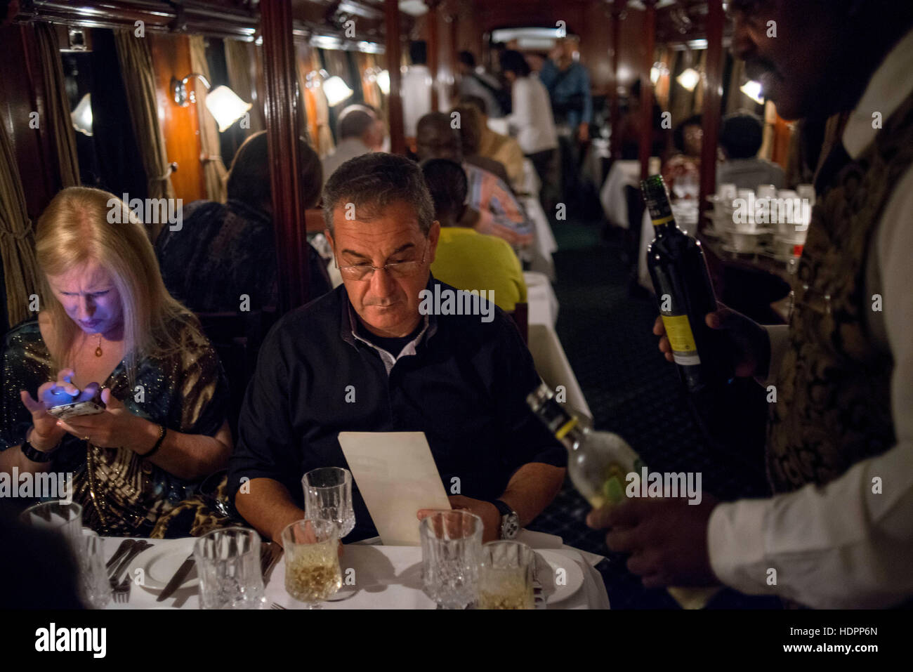 Inside the restaurant railway carriage of Royal Livingstone Express luxury train. The ambiance of the dining carriage offers more than warm elegance. Stock Photo