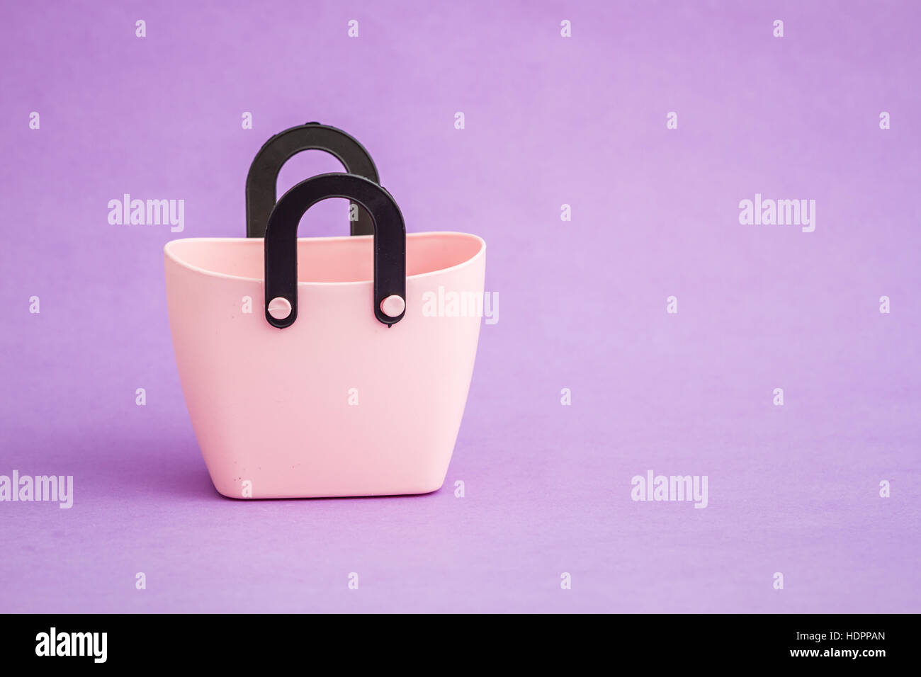 Small decorative plastic bags with handle on purple background Stock
