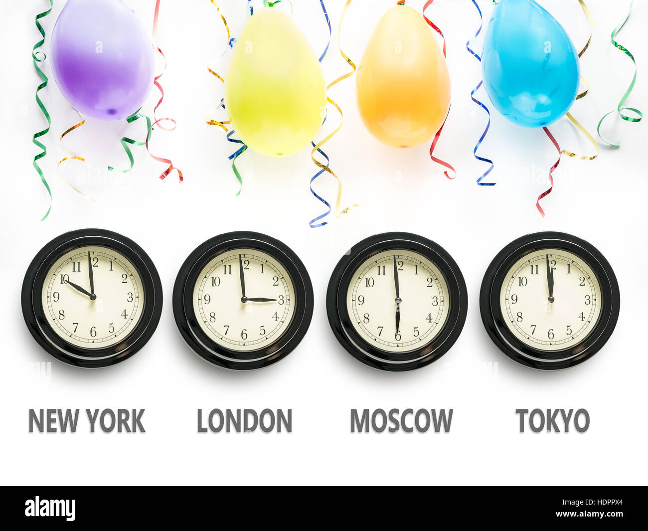 Four wall clocks indicating time zones for New York, London, Moscow and Tokyo with Tokyo time showing almost midnight and the New Year's Day Stock Photo