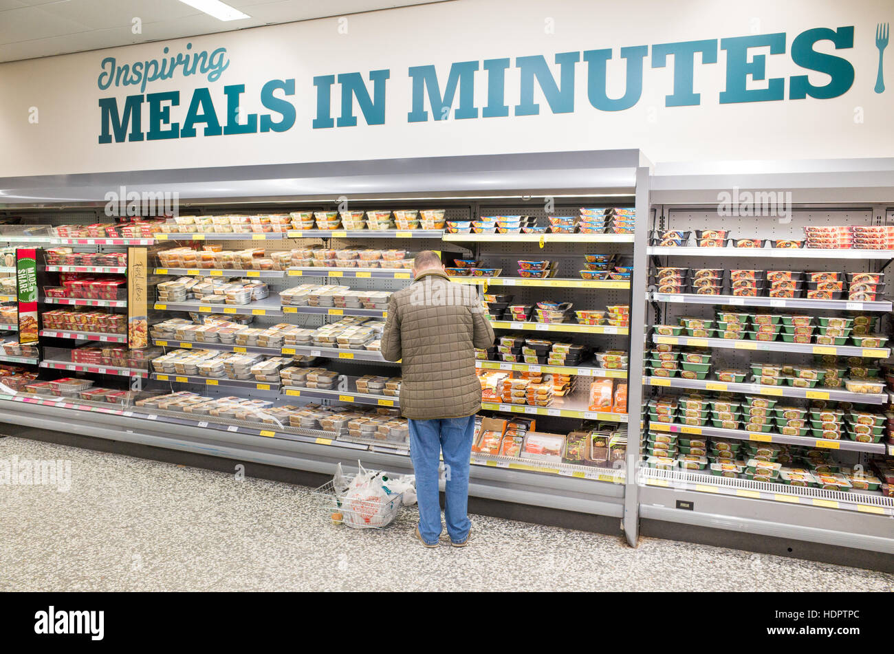 Elderly man shopping for ready meals at Morrisons supermarket, London