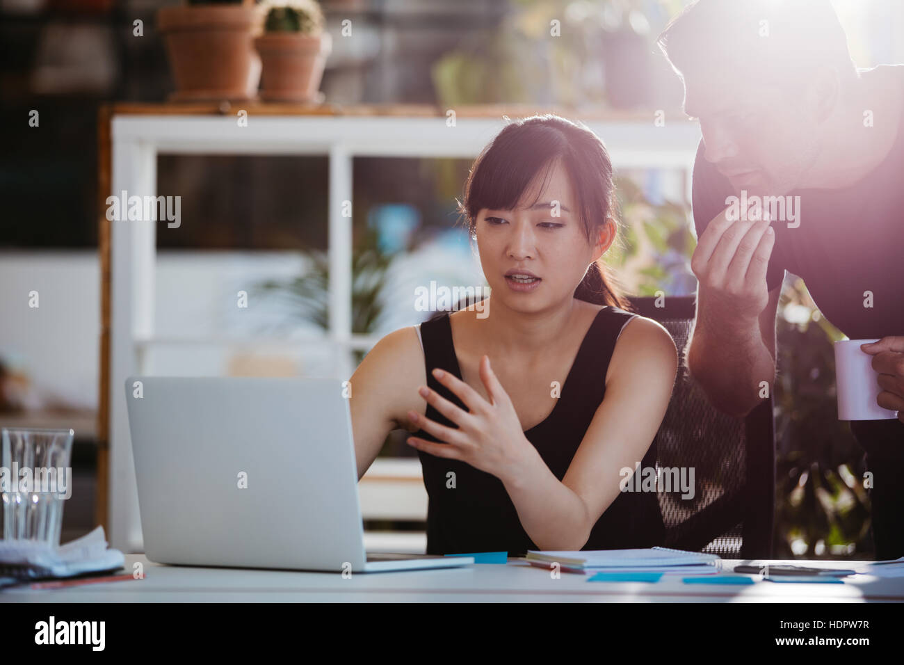 Shot of two young business colleagues looking at laptop. Businesspeople working together on laptop in office. Stock Photo