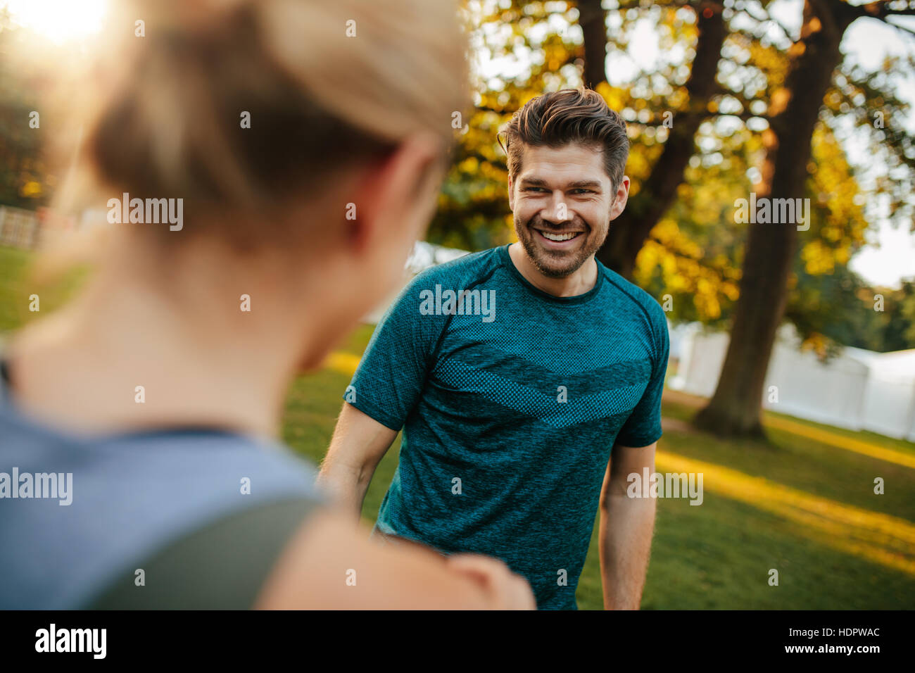 Shot of handsome and fit young man smiling with woman in park. Young couple at park. Stock Photo