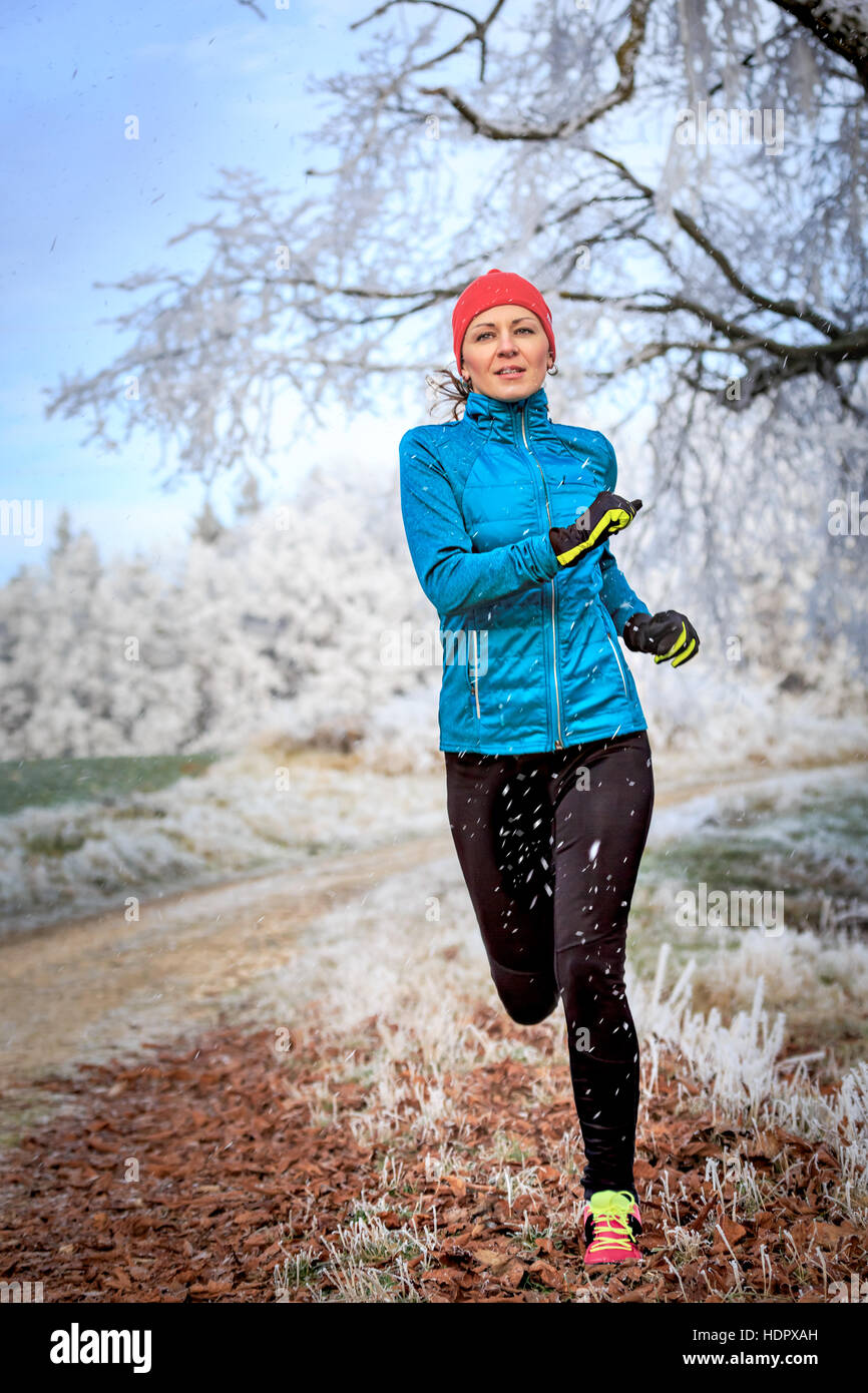 a young woman jogging in the wintry forest Stock Photo - Alamy