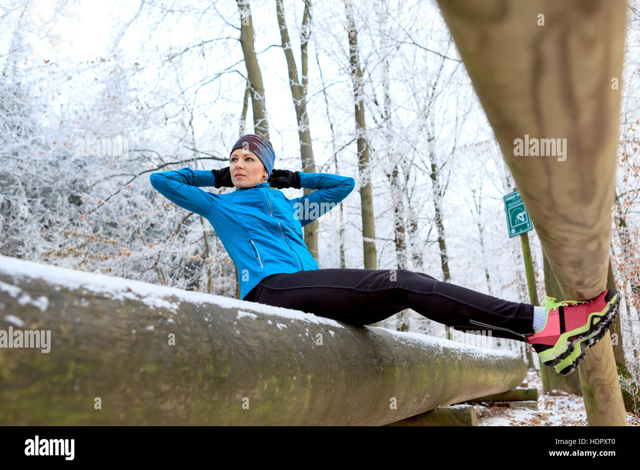 a young woman at physical activities on the Fitness Path in the wintry forest Stock Photo