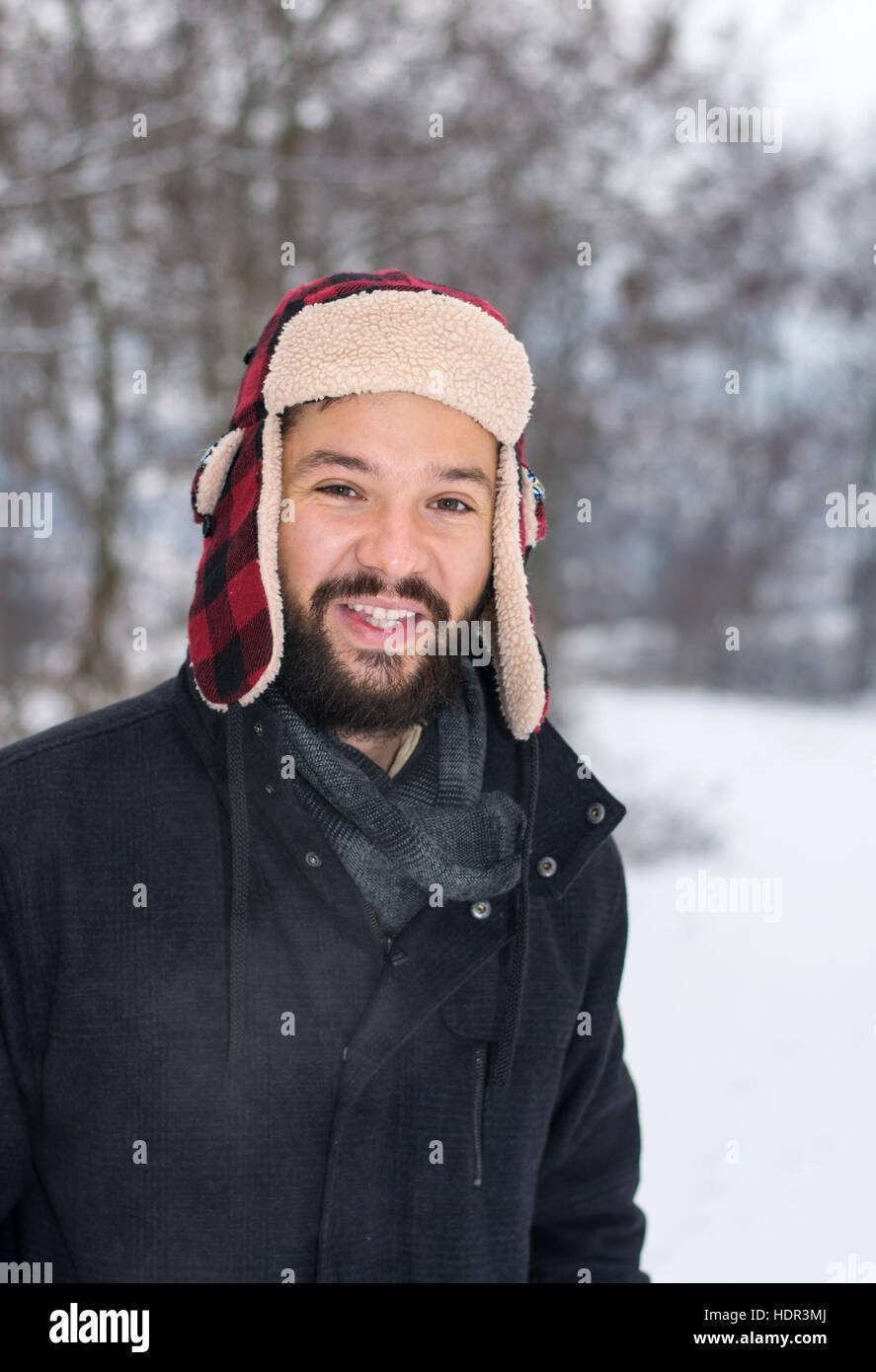 Happy man standing outdoors while it is snowing Stock Photo