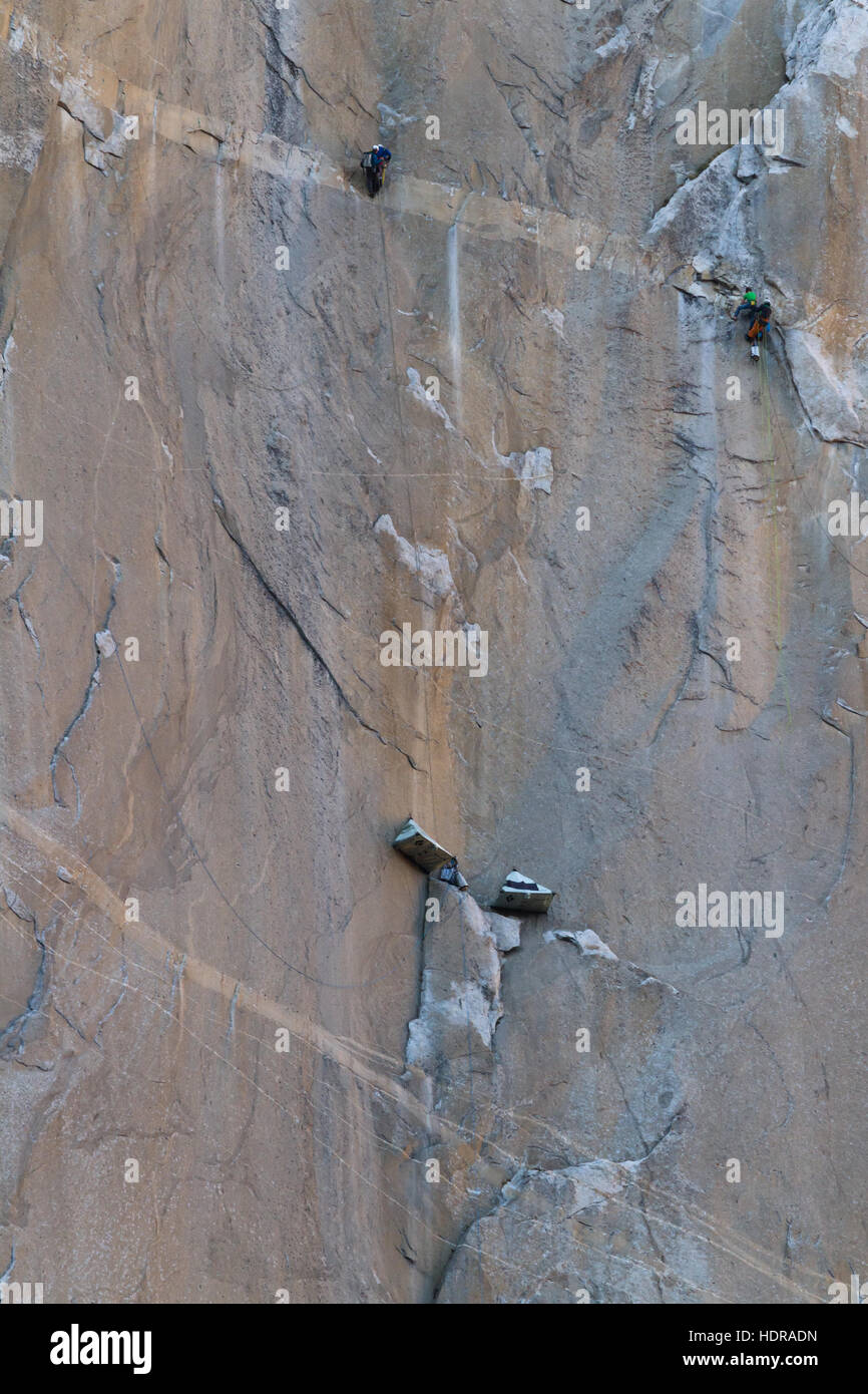 Camping tents suspended from the cliff and two sets of climbers on the